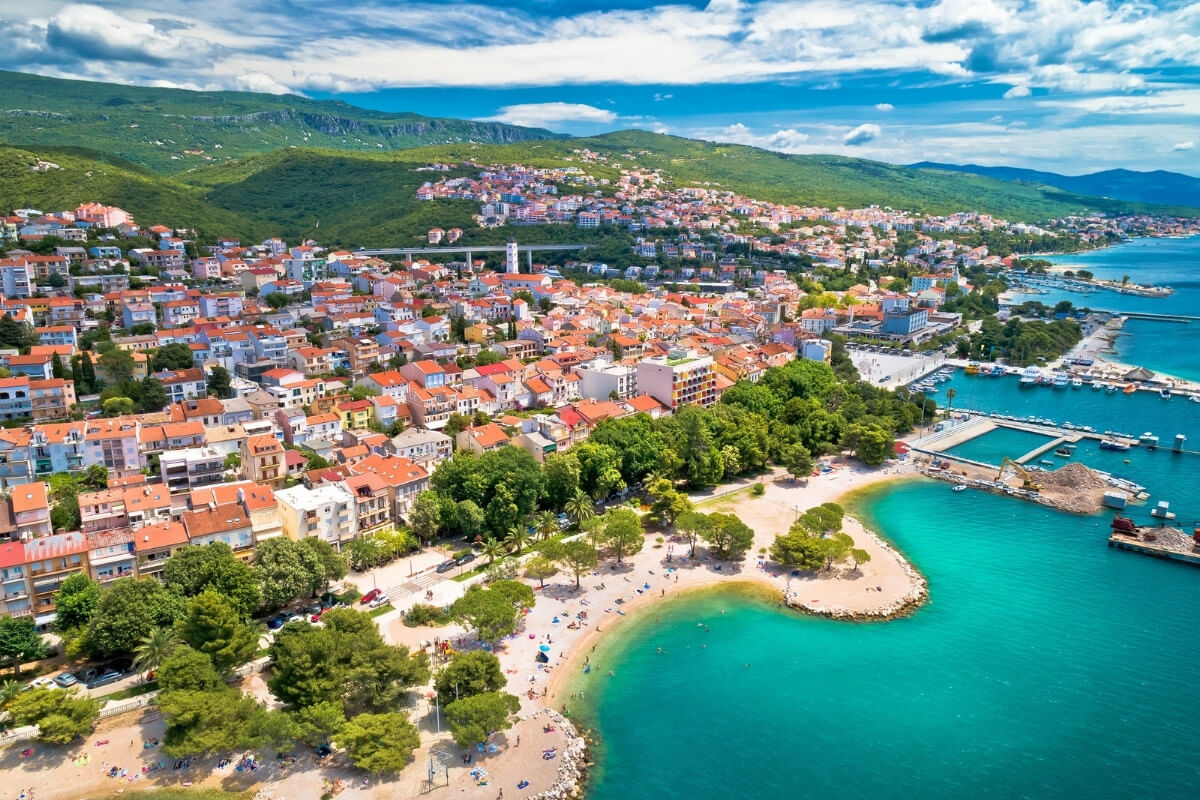 Jasi Tours városkép a tengerparti városról, ahol színes házak és zöld parkok találhatók a tengerparti sétány mellett, ideális nyaralási és utazási célpont.